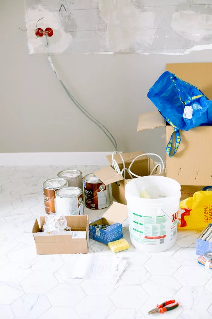 The Art of Drawing Readers In: Your attractive post title goes here A cluttered room with renovation supplies including paint cans, boxes, and tools.